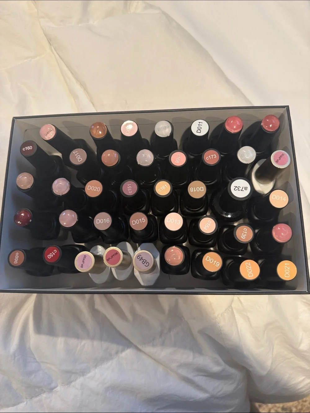 Collection of gel, nail polishes. Mostly light neutrals and dark neutrals.
